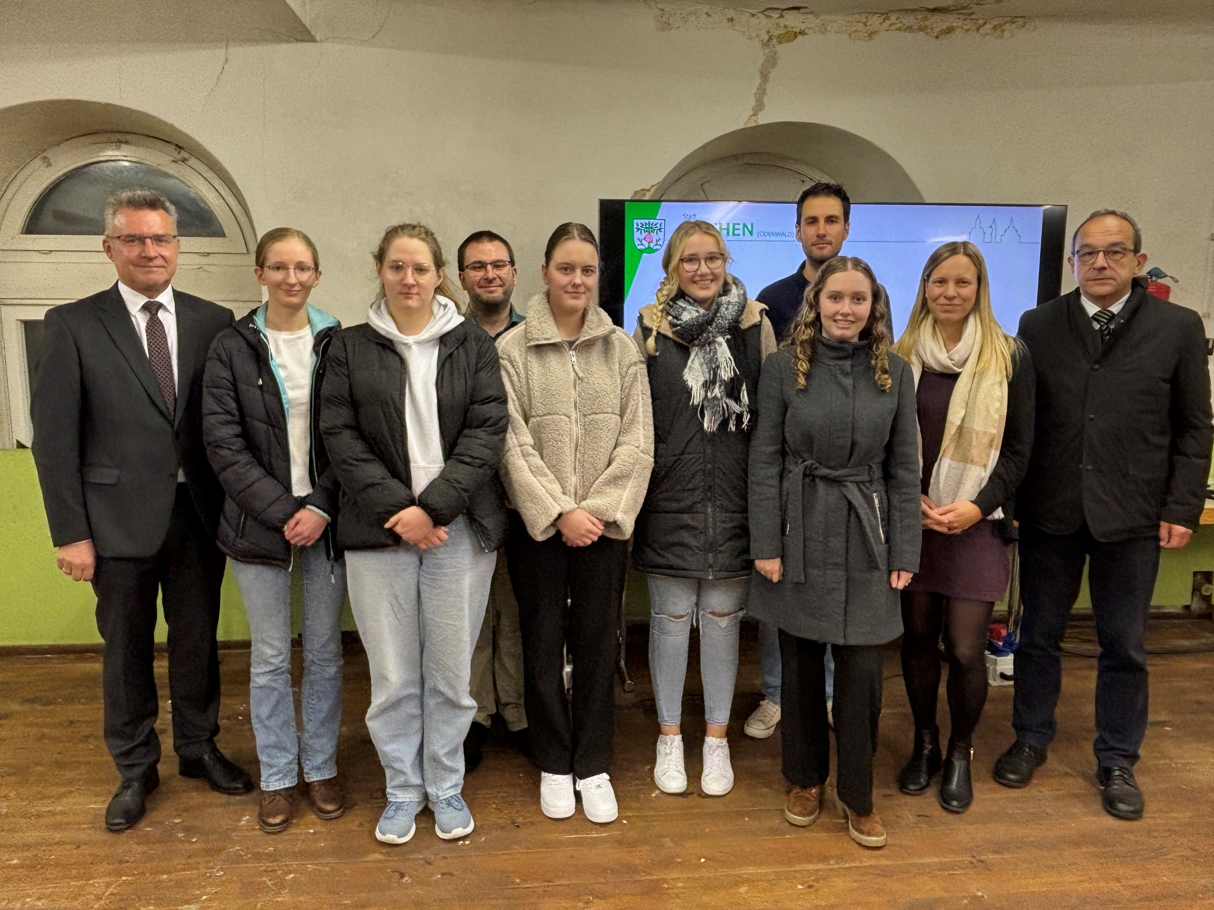 Die Beteiligten bei der Vorstellung des Gedenkporojektes. Von link: Landrat Dr. Achim Brötel, Lehrer Patrick Held, Stadtarchivar Tobias-Jan Kohler, Ortsvorsteherin Esther Vasko und Bürgermeister Roland Burger mit den Schülerinnen der Helene-Weber-Schule. (Foto: Tanja Radan)